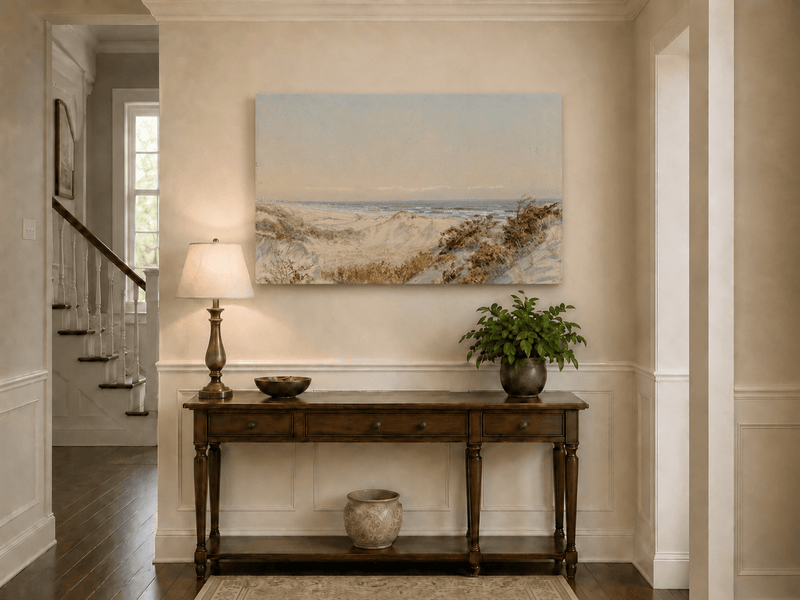 Unframed hand-painted coastal oil painting with sand dunes, beach grass and a calm ocean displayed above an entryway console table.