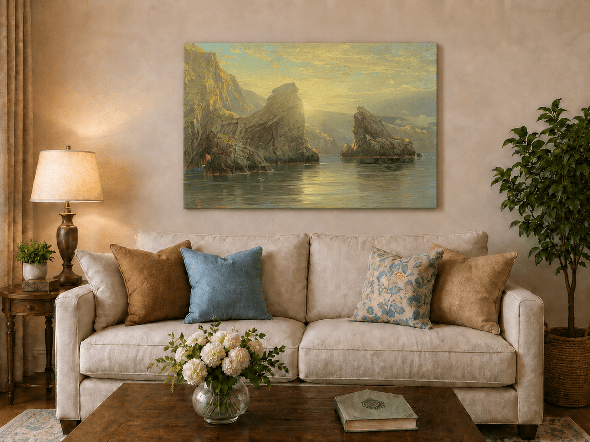 Unframed hand-painted seascape oil painting with rock cliffs, calm water and glowing skies displayed above a neutral living room sofa.