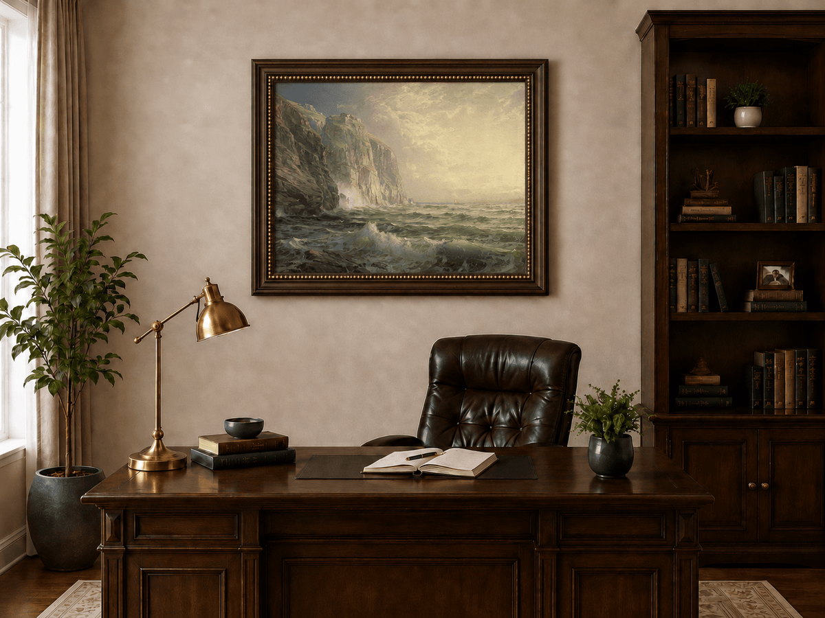 Framed hand-painted coastal oil painting with tall cliffs, rolling waves and glowing skies displayed above a traditional home office desk.