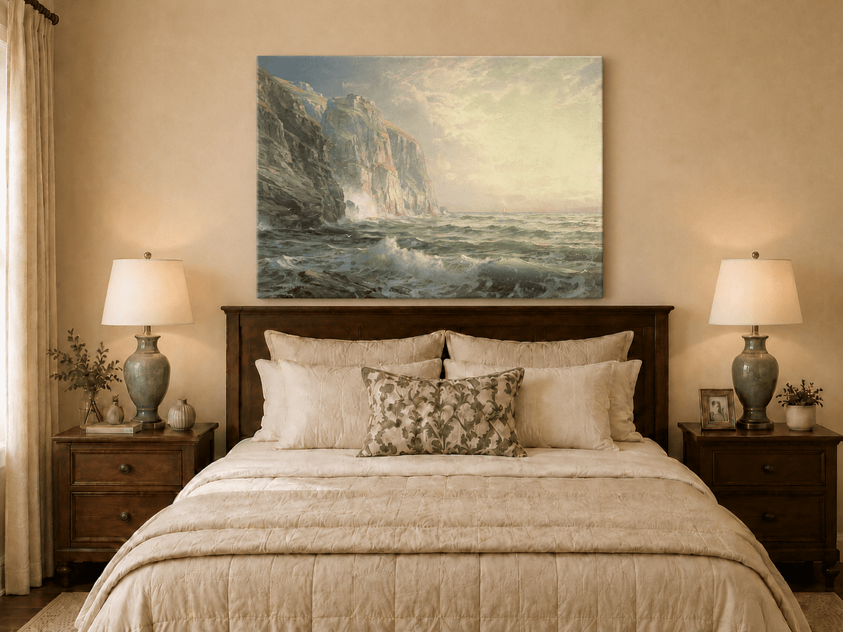 Unframed hand-painted coastal oil painting with tall cliffs, rolling waves and glowing skies displayed above a wooden bed in a neutral bedroom.