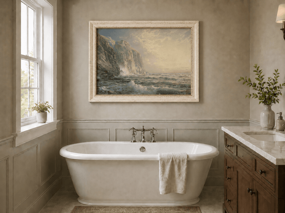 Framed hand-painted coastal oil painting with tall cliffs, rolling waves and glowing skies displayed above a freestanding bathtub.