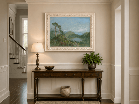 Framed hand-painted valley lake oil painting with tall pines, a blue bay and green hills displayed above an entryway console table.