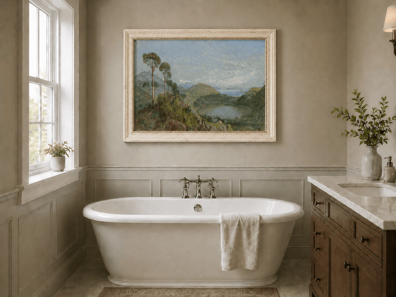 Framed hand-painted valley lake oil painting with tall pines, a blue bay and green hills displayed above a freestanding bathtub.