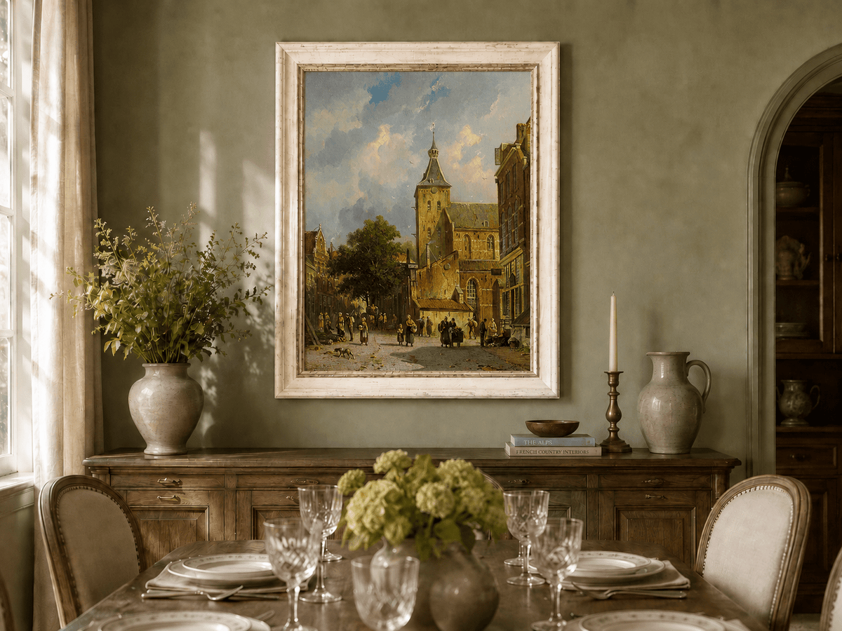Town square with church and figures oil landscape artwork shown in a styled home interior.