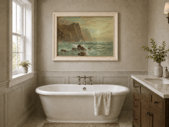 Framed hand-painted seascape oil painting with wave-washed rocks beneath soft-hued skies displayed above a freestanding bathtub.