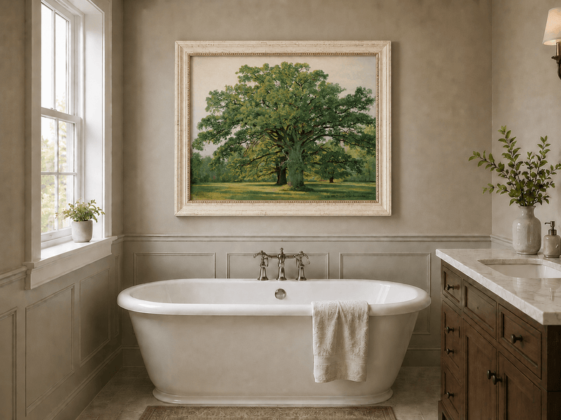 Framed hand-painted meadow oil painting with a majestic spreading oak tree displayed above a freestanding bathtub.