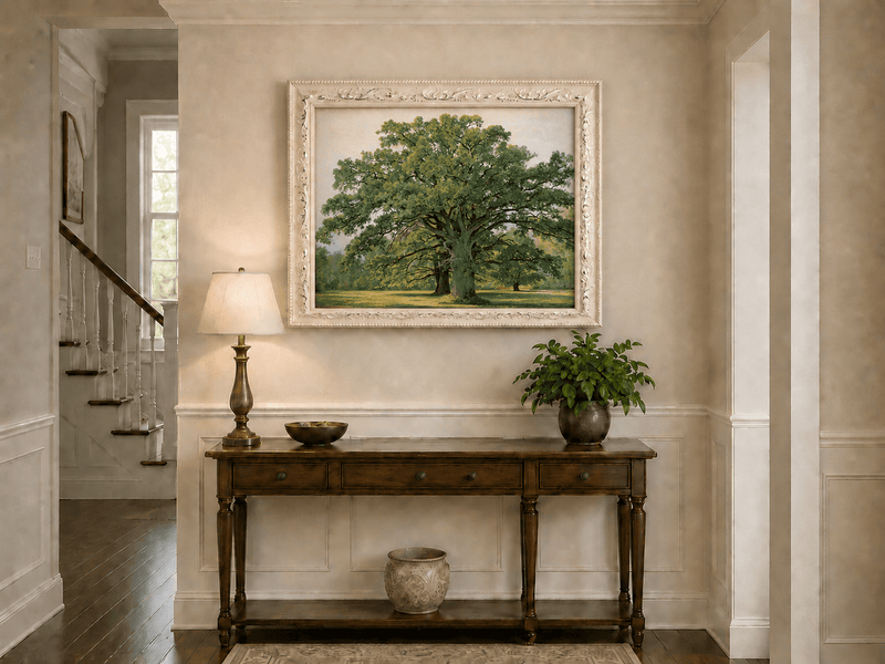 Framed hand-painted meadow oil painting with a majestic spreading oak tree displayed above an entryway console table.