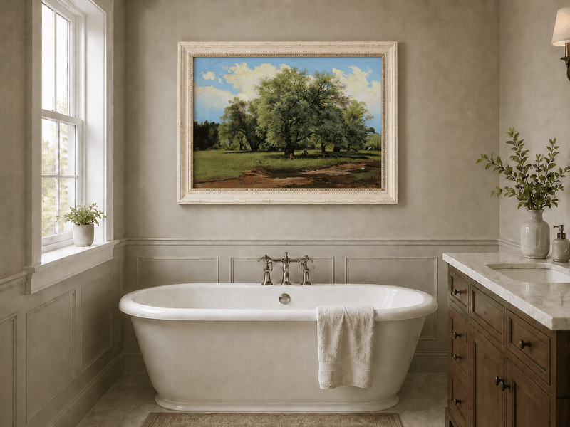 Framed hand-painted meadow oil painting with trees and small figures displayed above a freestanding bathtub.