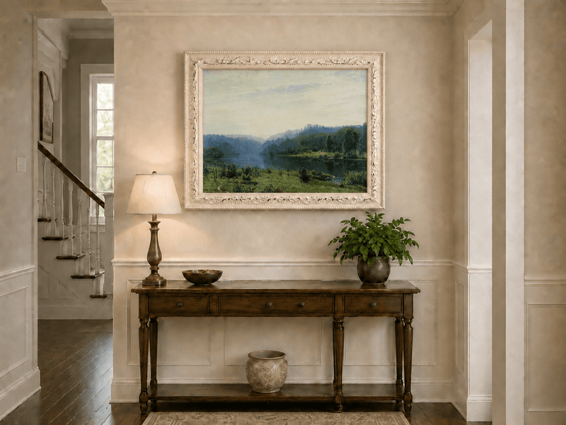 Framed hand-painted misty lake oil painting with a forested shore and distant hills displayed above an entryway console table.