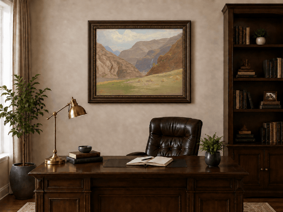 Framed hand-painted mountain canyon oil painting with a waterfall and grassy valley floor displayed above a traditional home office desk.