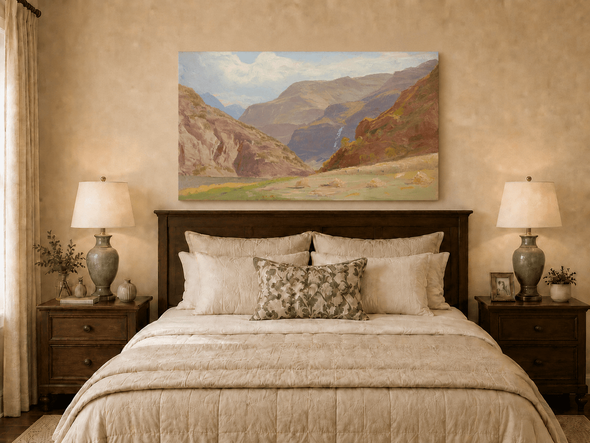 Unframed hand-painted mountain canyon oil painting with a waterfall and grassy valley floor displayed above a wooden bed in a neutral bedroom.