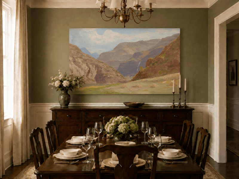 Unframed hand-painted mountain canyon oil painting with a waterfall and grassy valley floor displayed above a formal dining table.
