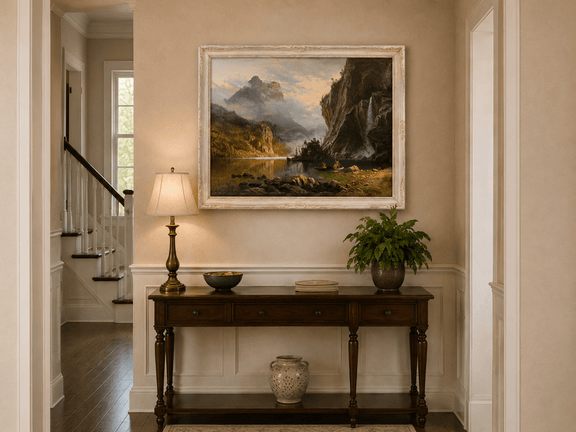 Framed hand-painted mountain lake oil painting with Native American figures in a canoe above an entryway console table.