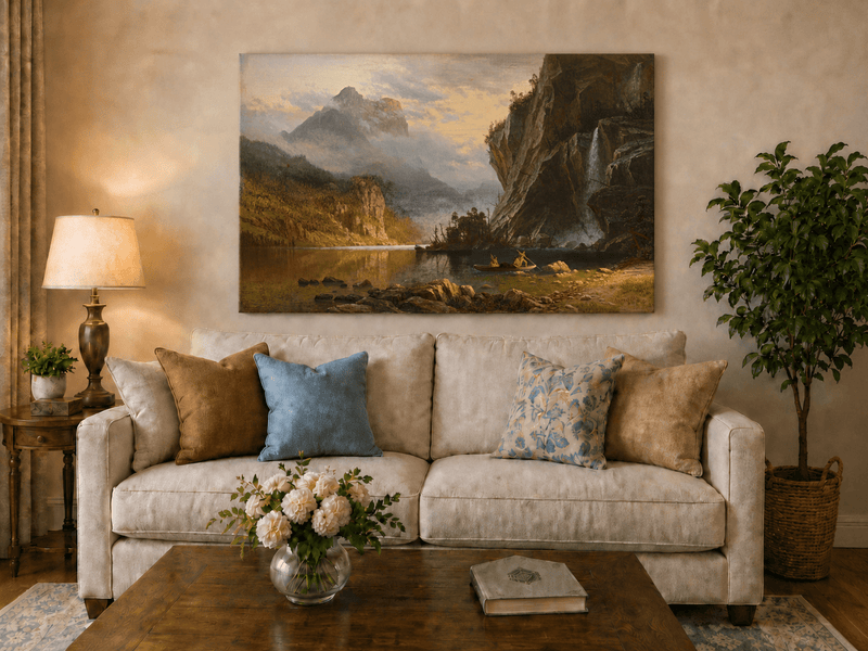 Unframed hand-painted mountain lake oil painting with Native American figures in a canoe above a neutral living room sofa.