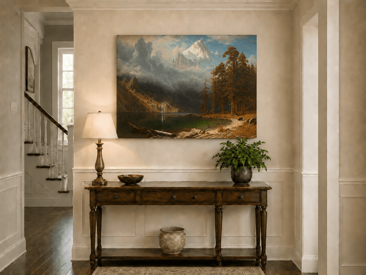 Unframed hand-painted mountain lake oil painting with redwood trees and a bear displayed above an entryway console table.