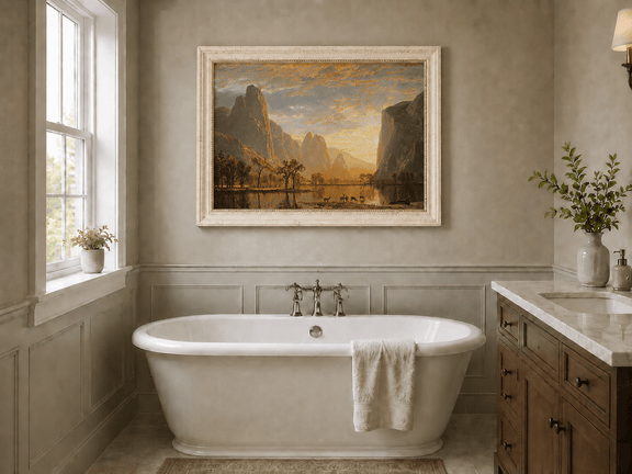 Framed hand-painted mountain lake oil painting with deer beneath a golden sunset displayed above a freestanding bathtub.