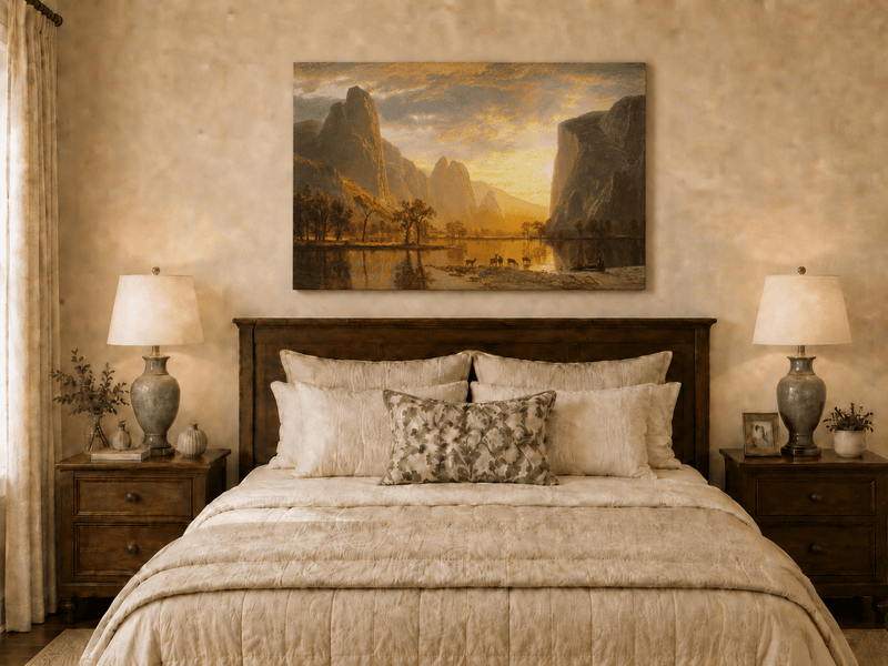 Unframed hand-painted mountain lake oil painting with deer beneath a golden sunset displayed above a wooden bed in a neutral bedroom.