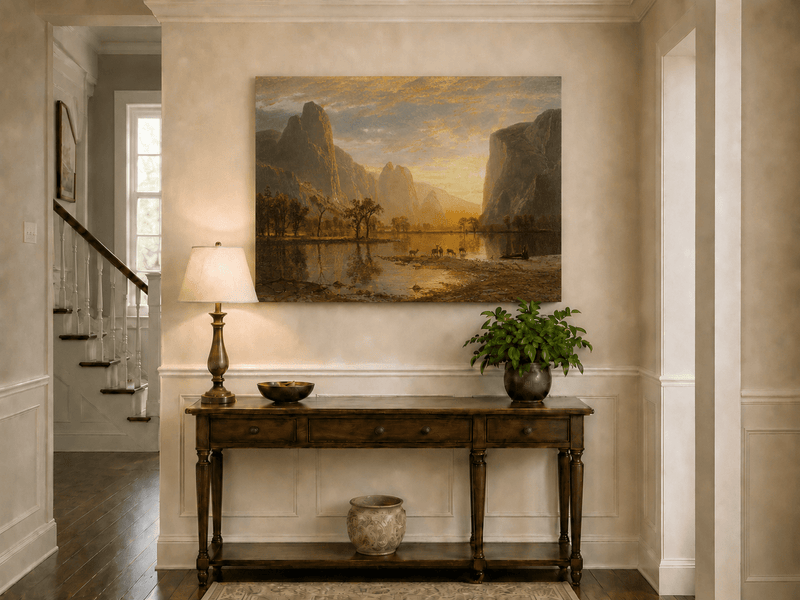 Unframed hand-painted mountain lake oil painting with deer beneath a golden sunset displayed above an entryway console table.