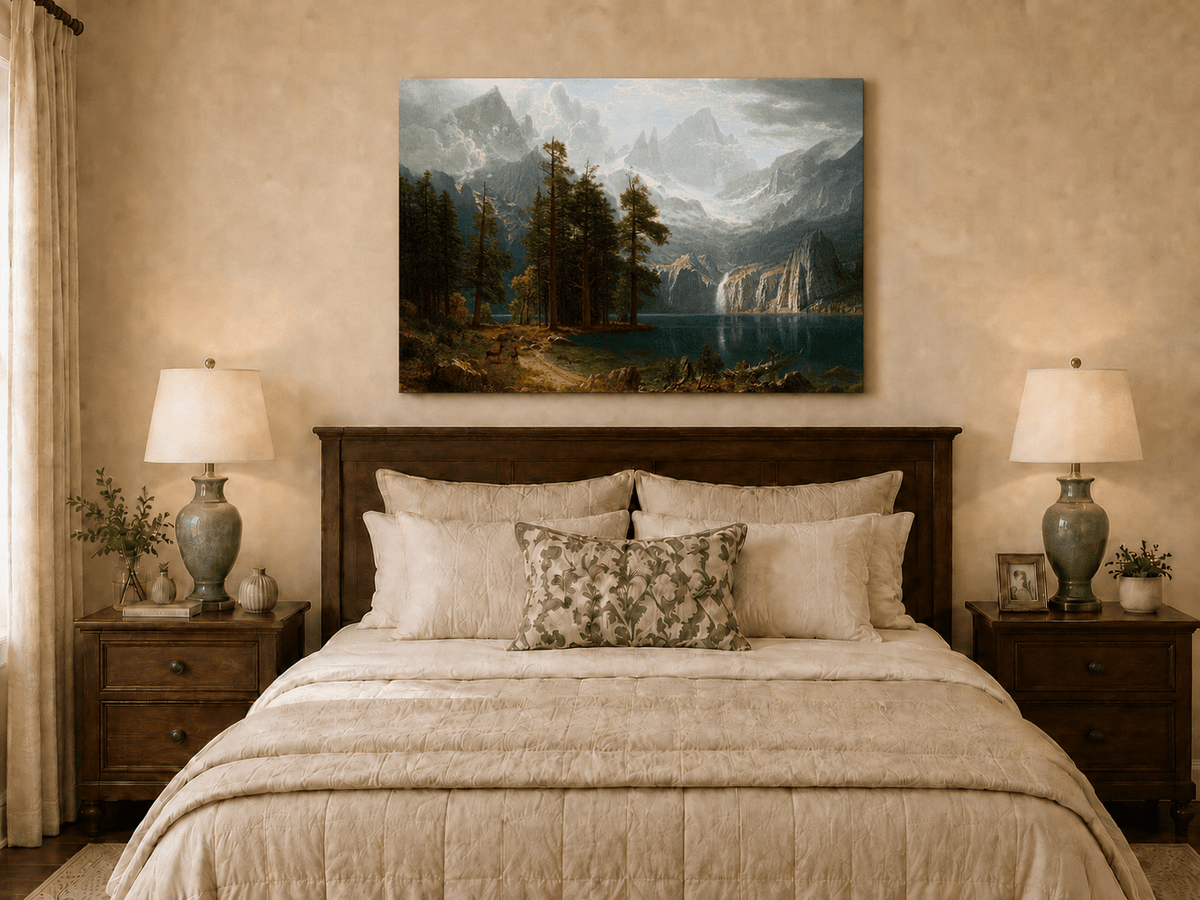 Unframed hand-painted mountain lake oil painting with pine forest, waterfall and misty peaks displayed above a wooden bed in a neutral bedroom.