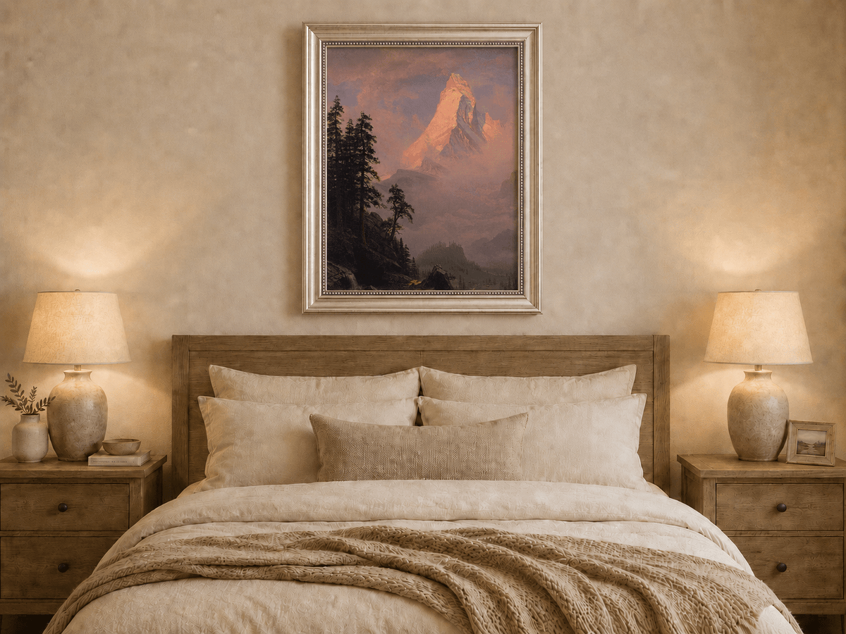 Framed hand-painted mountain oil painting with a sunlit peak, dark forest and mist displayed above a wooden bed in a neutral bedroom.