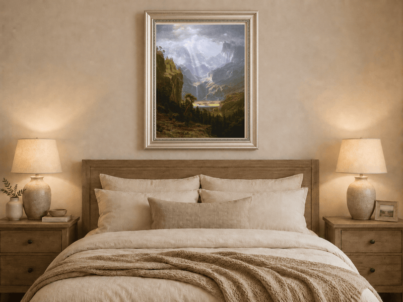 Framed hand-painted mountain valley oil painting with a waterfall and lake displayed above a wooden bed in a neutral bedroom.