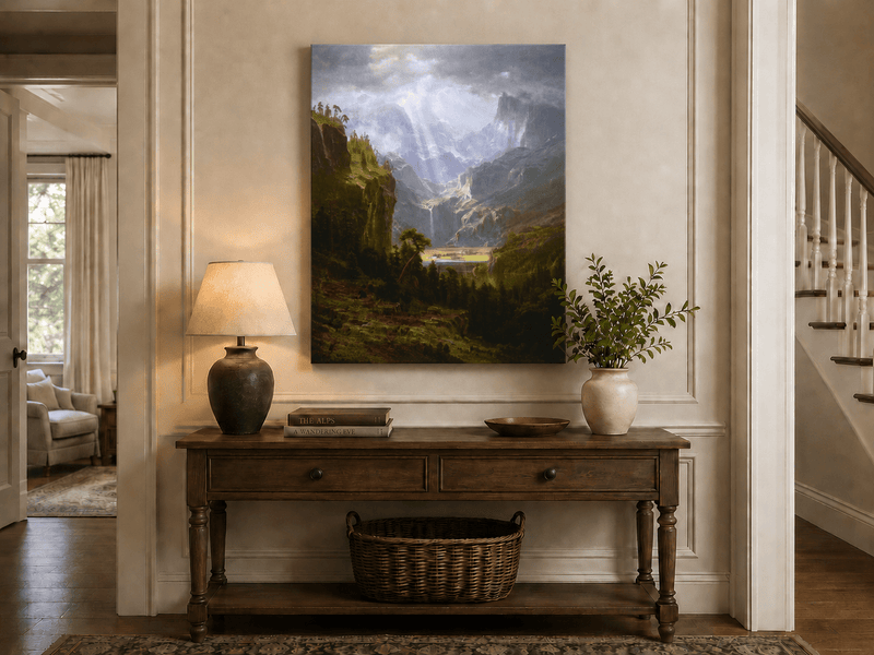 Unframed hand-painted mountain valley oil painting with a waterfall and lake displayed above an entryway console table.
