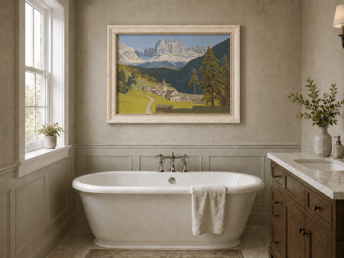 Framed hand-painted alpine landscape oil painting with a mountain village, church and path displayed above a freestanding bathtub.