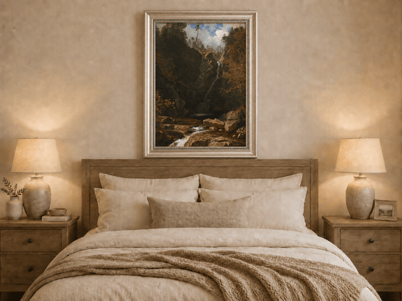 Framed hand-painted mountain waterfall oil painting through a dark autumn forest displayed above a wooden bed in a neutral bedroom.