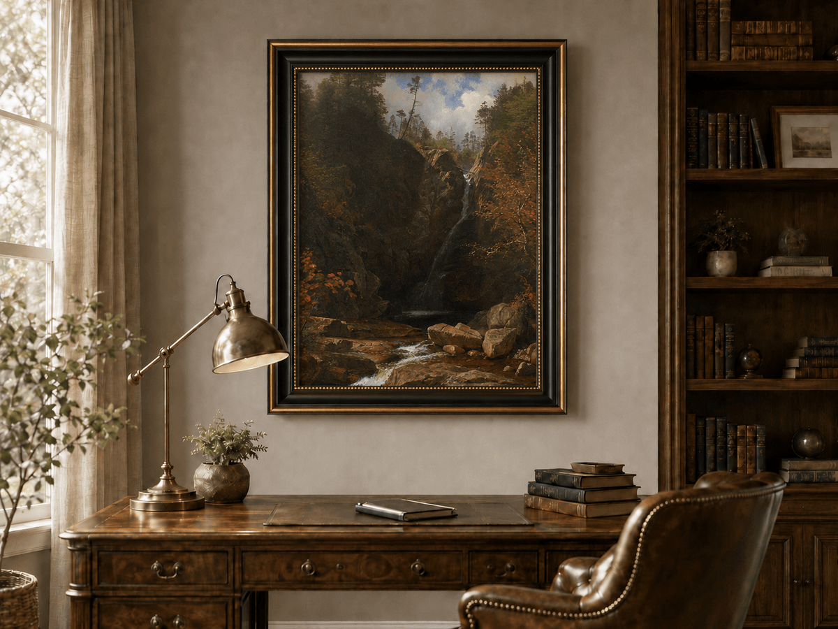 Framed hand-painted mountain waterfall oil painting through a dark autumn forest displayed above a traditional home office desk.
