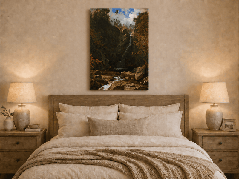 Unframed hand-painted mountain waterfall oil painting through a dark autumn forest displayed above a wooden bed in a neutral bedroom.