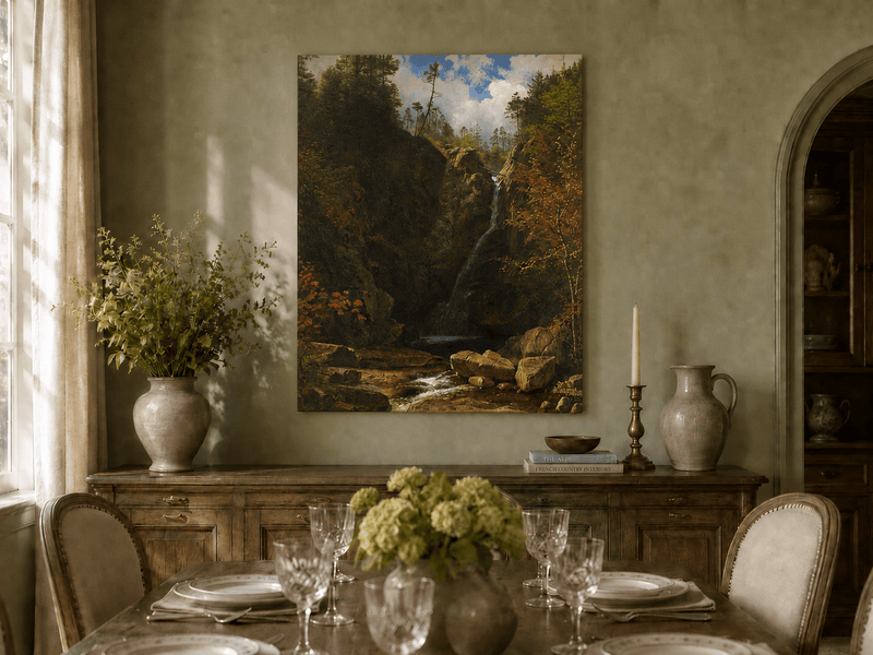 Unframed hand-painted mountain waterfall oil painting through a dark autumn forest displayed above a formal dining table.