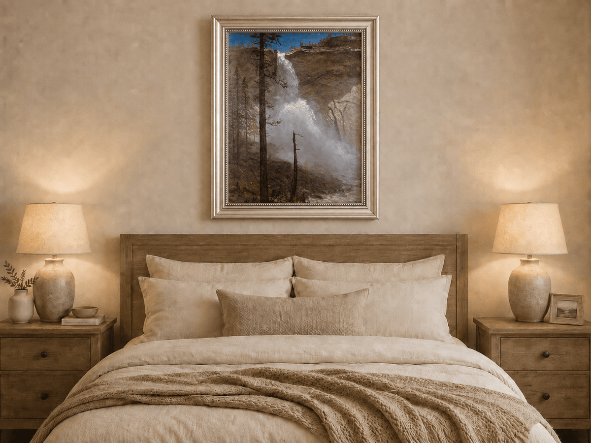 Framed hand-painted mountain waterfall oil painting with rocky cliffs and pine forest displayed above a wooden bed in a neutral bedroom.