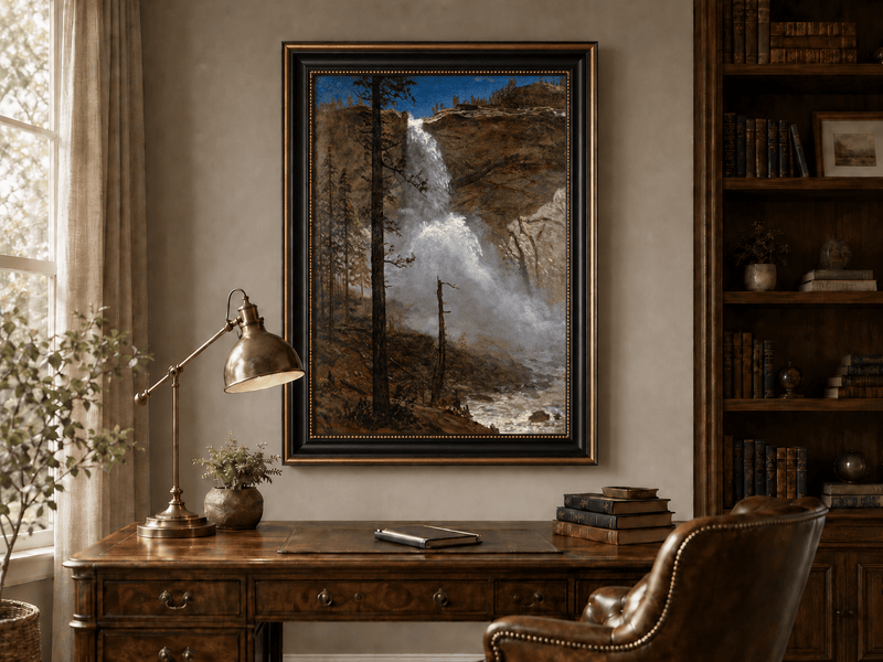 Framed hand-painted mountain waterfall oil painting with rocky cliffs and pine forest displayed above a traditional home office desk.