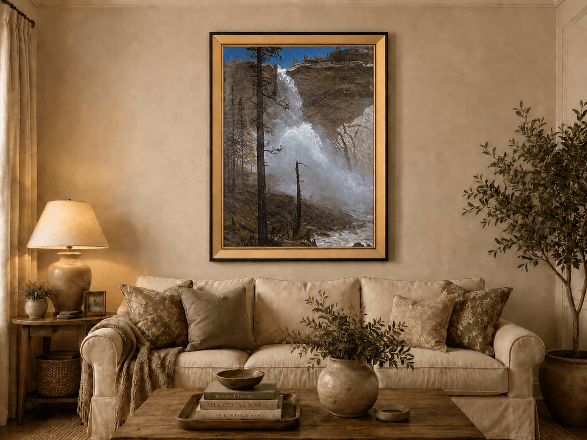 Framed hand-painted mountain waterfall oil painting with rocky cliffs and pine forest displayed above a neutral living room sofa.