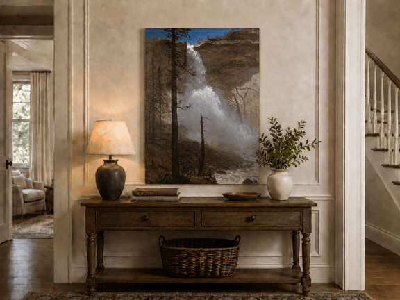 Unframed hand-painted mountain waterfall oil painting with rocky cliffs and pine forest displayed above an entryway console table.