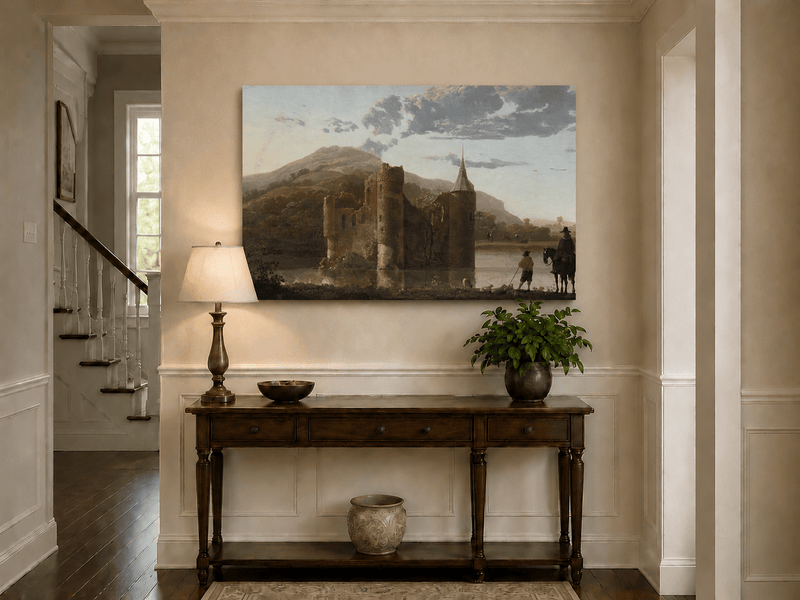 Unframed hand-painted castle ruins oil painting beside a lake with figures at sunset displayed above an entryway console table.