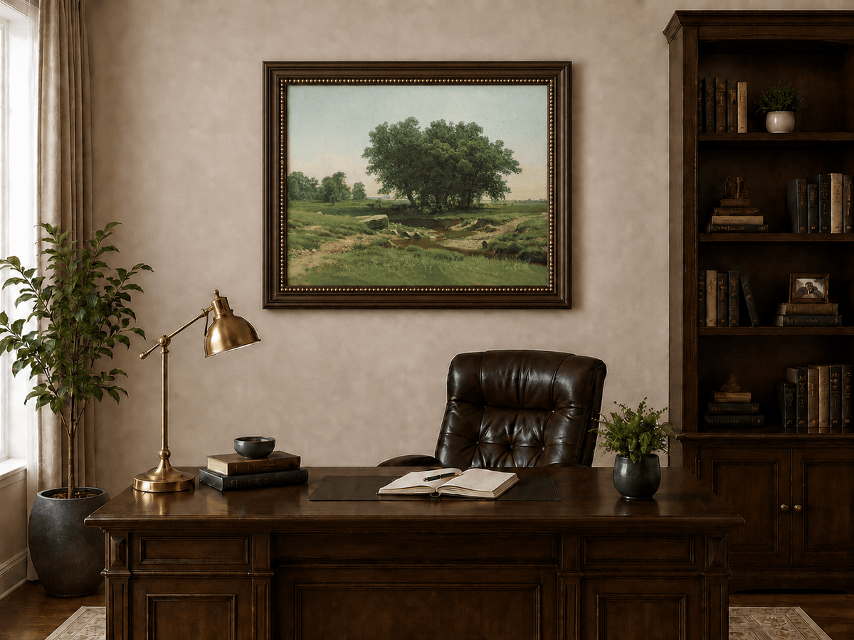 Framed hand-painted pastoral landscape oil painting with broad trees and a winding stream displayed above a traditional home office desk.