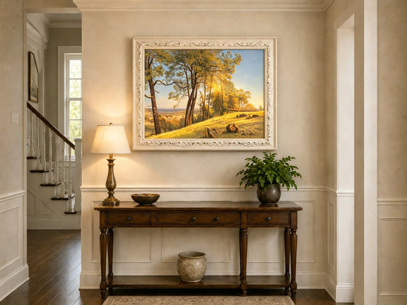 Framed hand-painted pine tree landscape oil painting on a bright sunlit hill displayed above an entryway console table.