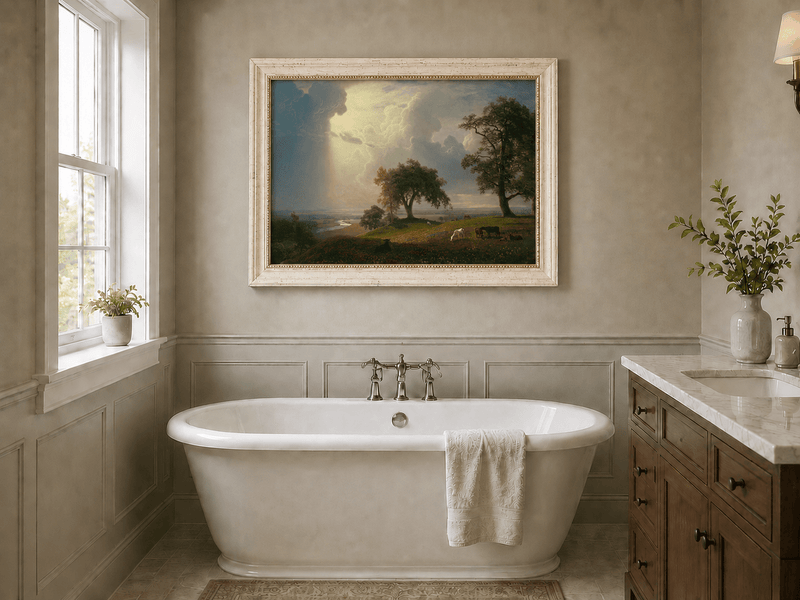 Framed hand-painted prairie oil painting with cattle beneath dramatic sunbeams displayed above a freestanding bathtub.