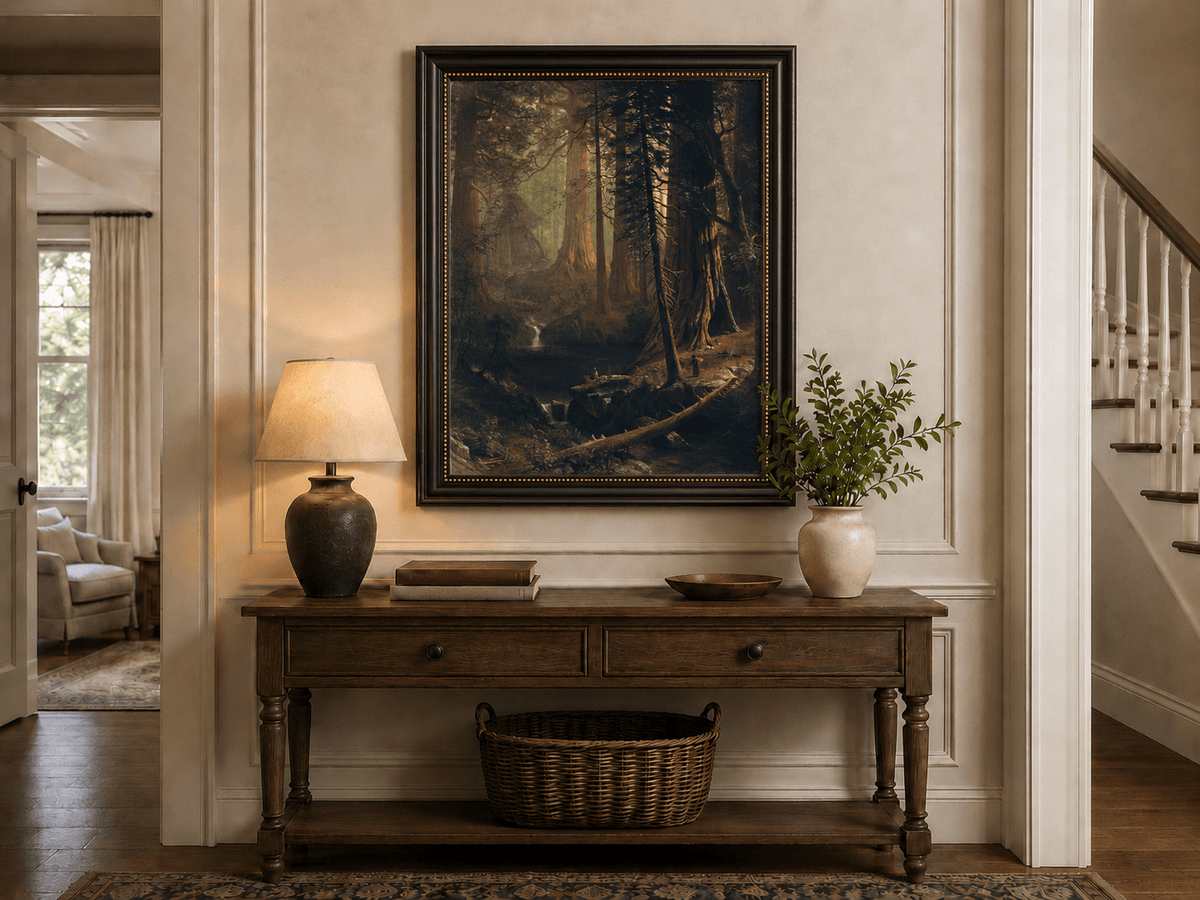 Framed hand-painted redwood forest oil painting with towering trees and filtered light displayed above an entryway console table.
