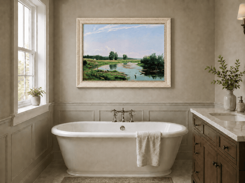 Framed hand-painted countryside oil painting with a winding river, green fields and trees displayed above a freestanding bathtub.