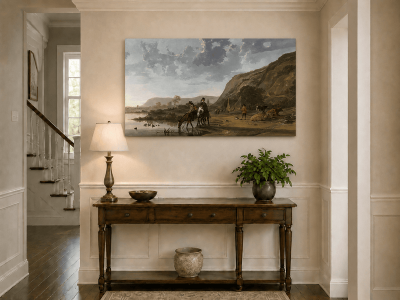 Unframed hand-painted riverside landscape oil painting with figures and animals beneath rocky hills displayed above an entryway console table.