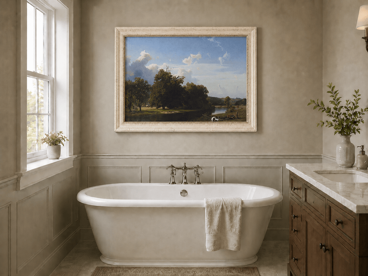 Framed hand-painted riverside oil painting with a large oak tree, boat and distant cottage displayed above a freestanding bathtub.