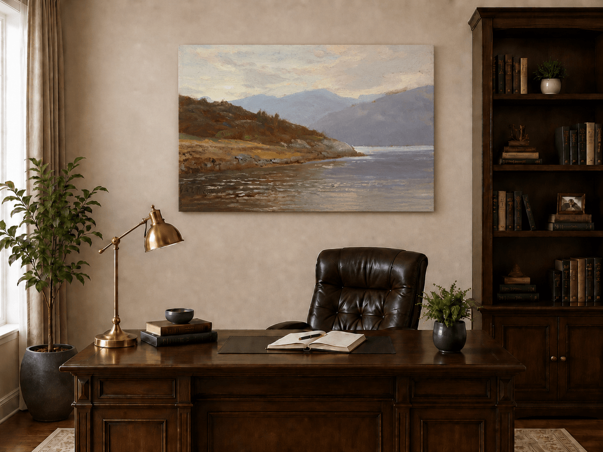 Unframed hand-painted lake shore oil painting with rocky banks, vegetation and mountain ranges displayed above a traditional home office desk.