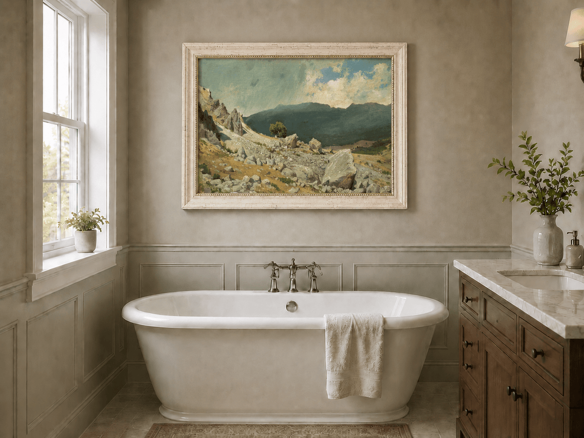 Framed hand-painted alpine oil painting with a rocky slope and distant mountain peaks displayed above a freestanding bathtub.