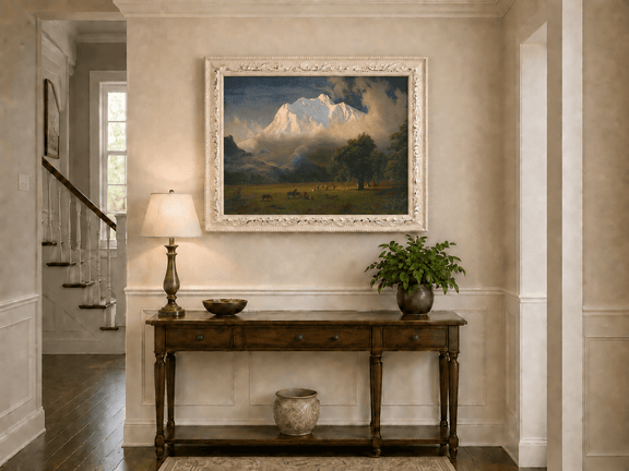 Framed hand-painted Rocky Mountains oil painting of Lander's Peak above a dramatic valley displayed above an entryway console table.