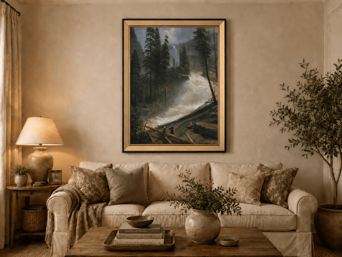 Framed hand-painted forest oil painting with figures beside a rushing river and waterfall displayed above a neutral living room sofa.