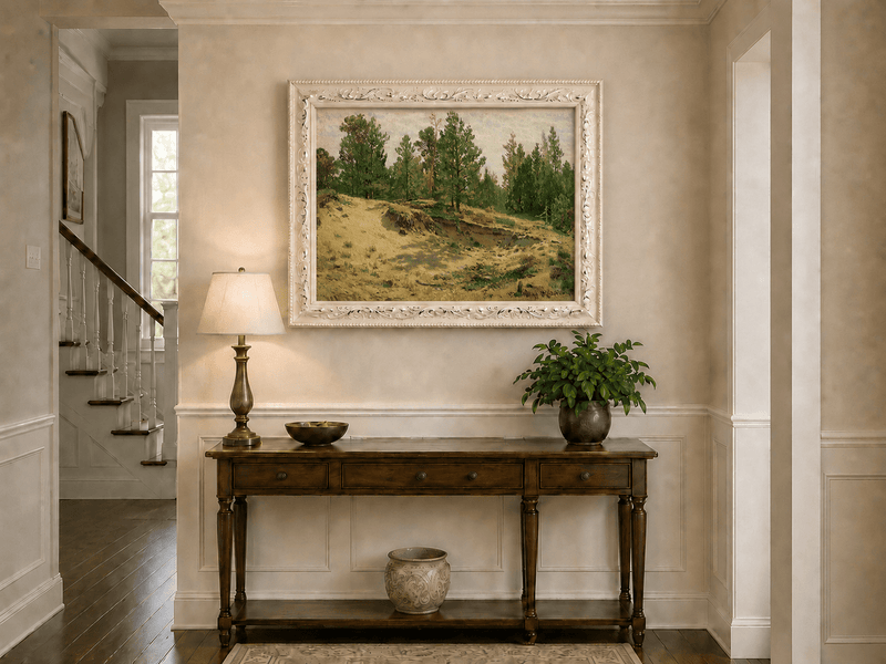 Framed hand-painted sandy forest clearing oil painting with scattered pines and open ground displayed above an entryway console table.