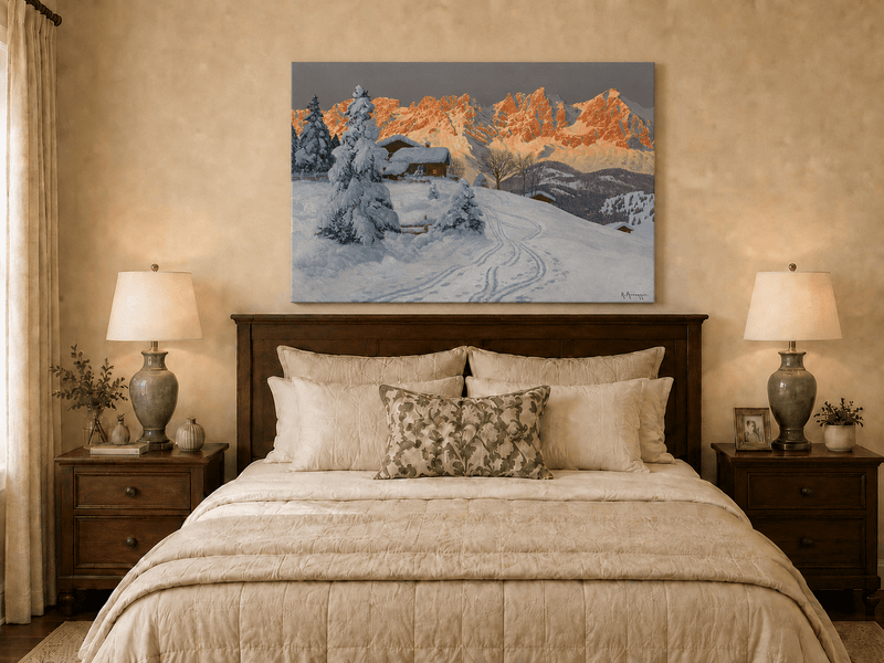 Unframed hand-painted winter alpine oil painting with a snowy cabin and mountains at sunset displayed above a wooden bed in a neutral bedroom.