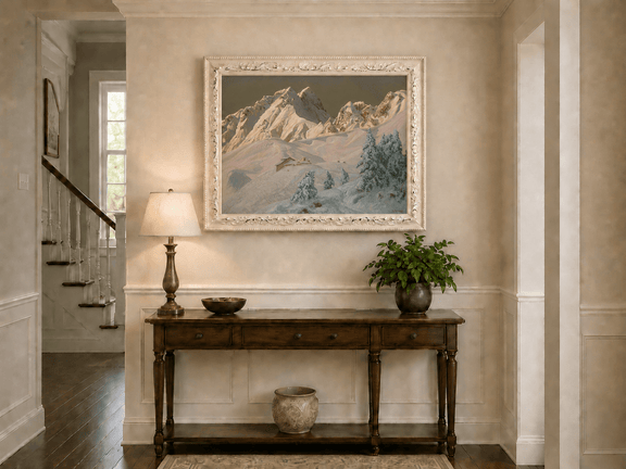 Framed hand-painted alpine oil painting with snowy mountain peaks glowing at dawn displayed above an entryway console table.